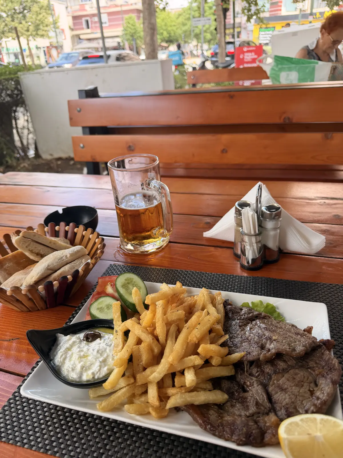 A relaxed restaurant terrace with a beer and a meal overlooking the Albanian coast.