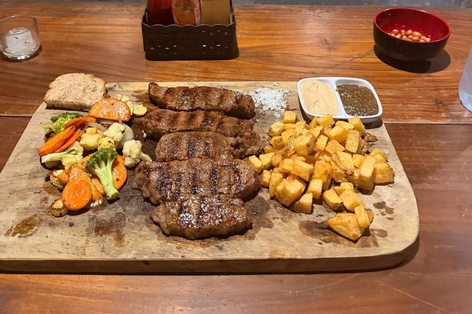 A grilled steak board with fries and vegetables at an open-grill restaurant in Canggu, Bali.