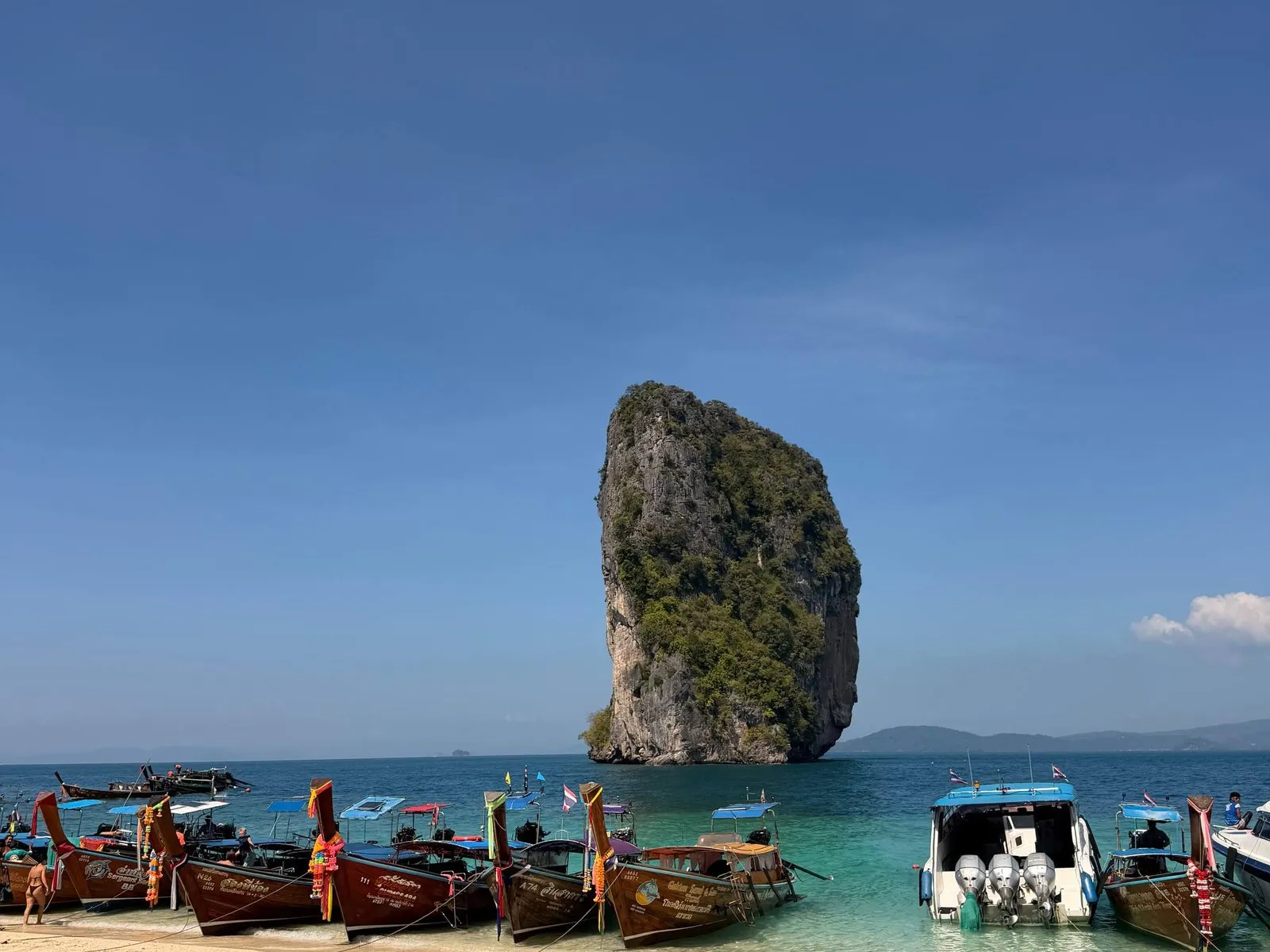 Poda Island with its limestone tower and longtail boats near Krabi, Thailand.